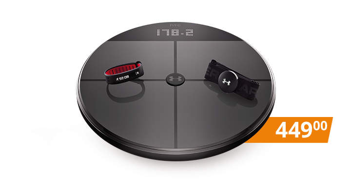 Eine runde Digitalwaage, auf deren Display „178,2“ angezeigt wird. Sie hat eine schwarze Oberfläche mit zwei Fitness-Accessoires darauf: ein rot-schwarzes Band und ein schwarzes Band mit weißem Logo. Auf einem orangefarbenen Etikett steht „449,00“.