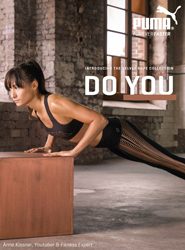 Eine Frau macht in einem rustikalen Fitnessstudio Liegestütze mit den Händen auf einem Holzblock. Sie trägt schwarze Sportbekleidung. Das Bild zeigt das Puma-Logo und den Slogan „DO YOU“.
