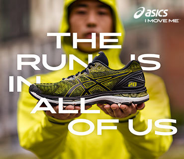 Eine Person in einem gelben Kapuzenpullover hält einen grün-schwarzen Asics-Laufschuh nach vorne. Darüber ist der Text „THE RUN IS IN ALL OF US“ gelegt. In der oberen rechten Ecke erscheint das Asics-Logo.