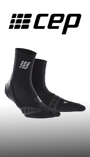 Ein Paar schwarze CEP-Söckchen, aufrecht vor einem weiß-grauen Hintergrund mit Farbverlauf. Das CEP-Logo ist oben auf jeder Socke und oben im Bild zu sehen. Die Socken haben ein strukturiertes Design mit verstärkten Bereichen.