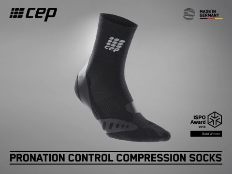 Bild einer schwarzen CEP-Kompressionssocke zur Pronationskontrolle. Der Hintergrund ist grau. Der Text auf dem Bild enthält „Made in Germany“, „ISPO Award 2018 Gold Winner“ und „Kompressionssocken zur Pronationskontrolle“. Das CEP-Logo befindet sich oben links.