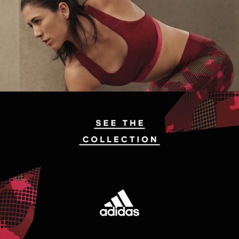 Eine Frau in einem roten Sport-BH und gemusterten Leggings streckt sich und lehnt sich nach vorne, wobei beide Hände auf den Knien ruhen. Darunter steht der Text „Siehe die Kollektion“ mit dem Adidas-Logo darunter.