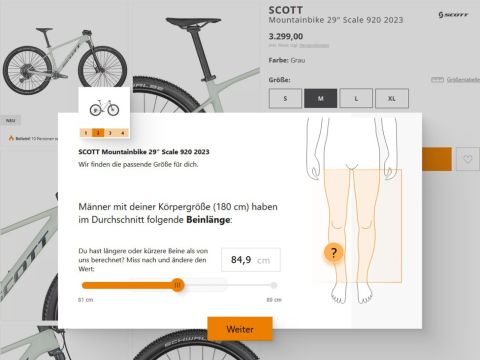 Screenshot eines Bike-Fitting-Tools auf einer Website. Gezeigt wird ein SCOTT Mountainbike, Modell Scale 920 2023, zum Preis von 3.299,00. Eine Grafik zeigt die durchschnittliche Beinlängenmessung für eine 180 cm große Person, mit einem Schieberegler zum Anpassen des Wertes.