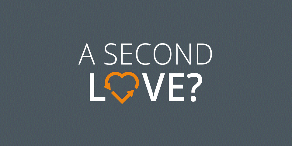 Das Bild hat einen dunkelgrauen Hintergrund mit dem Satz „A SECOND LOVE?“. Der Buchstabe „O“ in „LOVE“ wird durch ein orangefarbenes Herz mit zwei kreisförmigen Pfeilen darin ersetzt.
