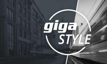 Geteiltes Schwarzweißbild: Links ist ein statisches Stadtgebäude zu sehen, rechts ein schnell fahrender Zug. Die Worte „giga STYLE“ sind in fetten Buchstaben in einem Kreis in der Mitte überlagert.
