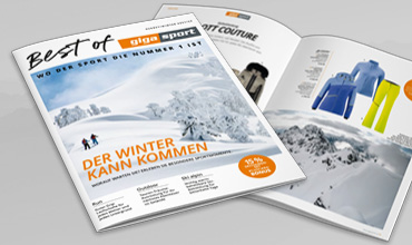 Es werden zwei Zeitschriften ausgestellt. Die vordere zeigt eine verschneite Berglandschaft mit dem Text „Der Winter kann kommen“. Die zweite Zeitschrift ist aufgeschlagen und zeigt Bilder von Winterkleidung. Der Text ist auf Deutsch.