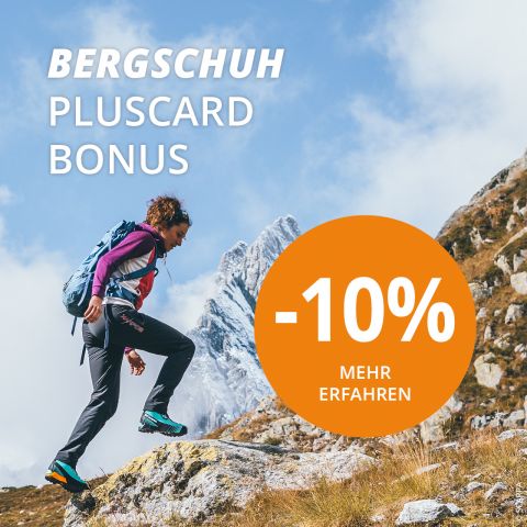 Eine Person in Wanderkleidung und mit Rucksack erklimmt ein felsiges Gelände mit einem schneebedeckten Berg im Hintergrund. Der darüber gelegte Text lautet „BERGSCHUH PLUSCARD BONUS“ und „-10% MEHR ERFAHREN“ in einem orangefarbenen Kreis.