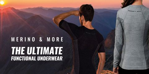Zwei Personen in Sportbekleidung aus Merinowolle stehen bei Sonnenuntergang auf einem Berggipfel. Der Text lautet „Merino & More: Die ultimative Funktionsunterwäsche“. Die Szene fängt die Silhouette schroffer Berge und eines farbenfrohen Himmels ein.