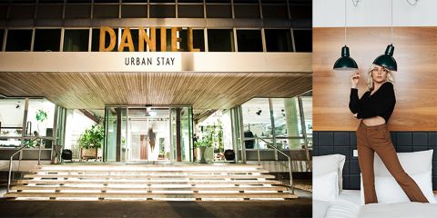 Das Bild zeigt den Eingang des „Daniel Urban Stay“ mit beleuchteten Stufen, die zu einer modernen Fassade führen. Rechts steht eine Person stilvoll auf einem Bett unter zwei Hängelampen in einem zeitgenössischen Raumambiente.