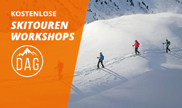 Drei Personen fahren unter klarem Himmel auf einem schneebedeckten Berg Ski. Auf der linken Seite ist ein orangefarbenes Overlay mit dem Text „KOSTENLOSE SKITOUREN WORKSHOPS“ und einem Logo mit „DAG“ zu sehen.