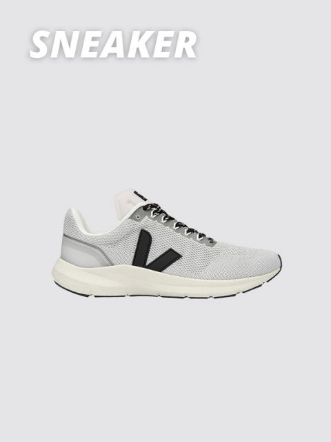 Ein grauer Sneaker mit schwarzen Details, weißer Sohle und einem markanten schwarzen „V“-Logo an der Seite. Das Wort „SNEAKER“ steht in fetter weißer Schrift oben links auf hellgrauem Hintergrund.