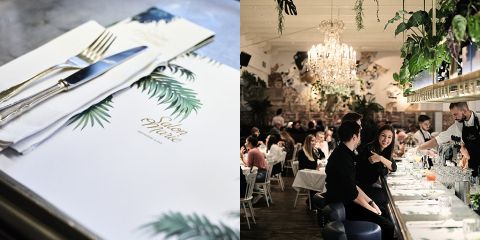 Links: Nahaufnahme einer Speisekarte und Besteck auf einem Tisch mit Palmenblattmuster. Rechts: Elegantes Restaurant-Interieur mit Kronleuchtern, Hängepflanzen und Gästen an der Bar und an den Tischen.