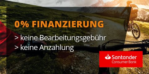 Eine Person radelt bei Sonnenuntergang auf einem Bergweg. Text lautet: „0% FINANZIERUNG, keine Bearbeitungsgebühr, keine Anzahlung.“ Logo der Santander Consumer Bank in der unteren rechten Ecke.