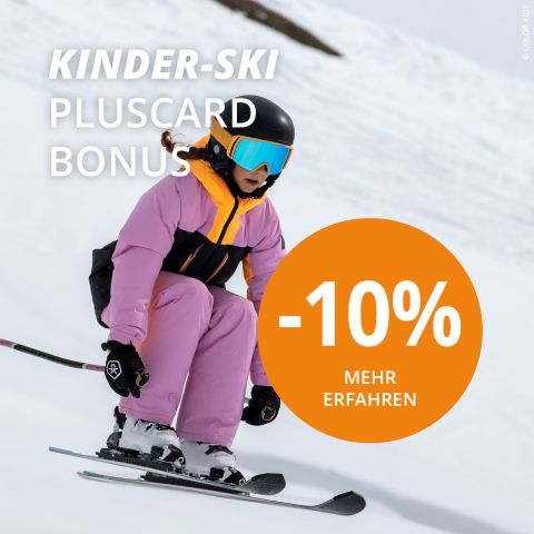 Ein Kind in rosa-schwarzem Skianzug und Skibrille fährt einen verschneiten Hang hinunter. Das Bild enthält den Text: „KINDER-SKI PLUSCARD BONUS“ und „-10 % MEHR ERFAHREN“ auf einem orangefarbenen Kreis.