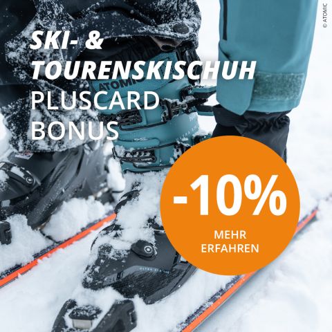 Eine Person passt auf einem verschneiten Hang die Bindung eines Skischuhs an. Sie trägt eine blaugrüne Skihose und benutzt Skier mit orangefarbenen Umrissen. Ein großer orangefarbener Kreis zeigt „-10 % Mehr Erfahren“ an und bietet einen Rabatt auf Ski- und Tourenschuhe.
