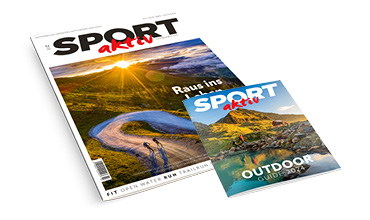 Abgebildet sind zwei SPORTaktiv-Hefte. Das größere Cover zeigt einen Sonnenaufgang über kurvenreichen Straßen und Radfahrern. Das kleinere Cover zeigt eine malerische Berglandschaft mit einem See.