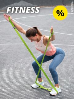 Eine Frau in Sportkleidung trainiert im Freien mit einem grünen Widerstandsband und macht Kniebeugen mit erhobenen Armen. Das Bild ist mit dem Wort „FITNESS“ und einem gelben Prozentzeichen überlagert.