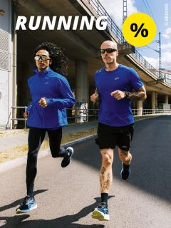 Zwei Personen joggen an einem sonnigen Tag im Freien; beide tragen blaue Sportkleidung. Über ihnen steht das Wort „RUNNING“ und ein gelber Kreis mit einem Prozentzeichen. Im Hintergrund sind eine Brücke und Betonkonstruktionen zu sehen.