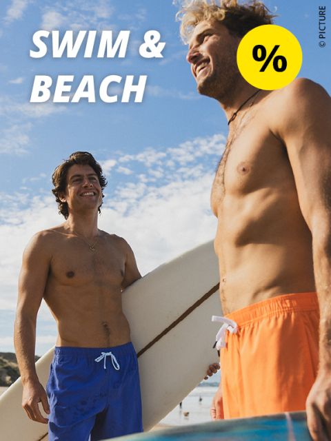 Zwei lächelnde Männer in Badehosen stehen mit einem Surfbrett am Strand. Der Himmel ist blau und bewölkt. Der Text lautet „SCHWIMMEN & STRAND“ mit einem gelben Prozentsymbol in der Ecke.