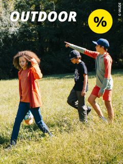 Drei Kinder spielen und spazieren auf einer sonnigen Wiese. Eines zeigt geradeaus. Das Wort „OUTDOOR“ und ein gelbes Prozentzeichen sind oben im Bild eingeblendet. Im Hintergrund sind Bäume zu sehen.