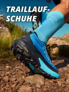 Nahaufnahme einer Person mit blauen Trailrunning-Schuhen auf einem felsigen Weg im Freien, mit der Aufschrift "TRAILLAUF-SCHUHE" in fetter weißer Schrift oben links. Die Logos der Schuhmarke "HOKA" und "Vibram" sind sichtbar.