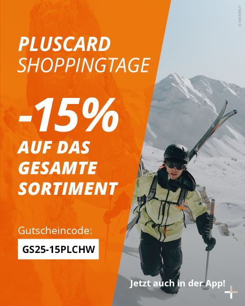 Eine Person in Skikleidung und mit Sonnenbrille trägt Skier einen verschneiten Berghang hinauf. Ein orangefarbenes Overlay wirbt für eine Pluscard-Einkaufsaktion mit 15 % Rabatt auf alle Artikel mit dem Code GS25-15PLCW und weist auf die Verfügbarkeit in der App hin.