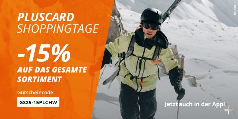 Ein Skifahrer in alpiner Ausrüstung erklimmt einen verschneiten Berg mit Skiern auf dem Rücken. Der orangefarbene Text wirbt für "PLUSCARD SHOPPINGTAGE: -15% auf das gesamte Sortiment" und enthält einen Rabattcode und einen Hinweis auf eine App.