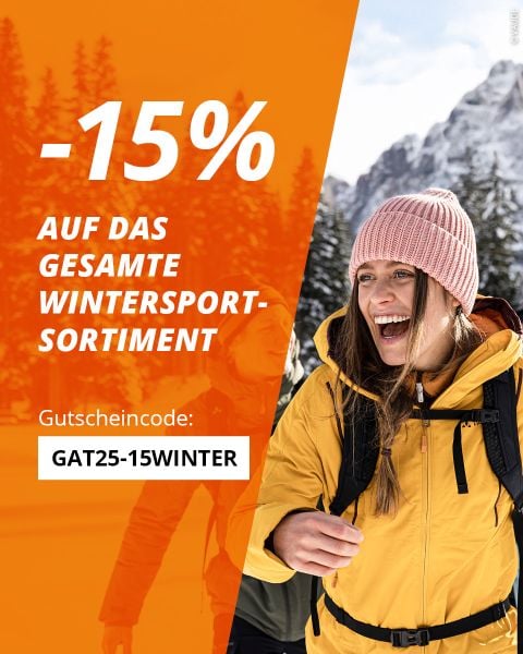 Eine lächelnde Frau in einer gelben Winterjacke und einer rosa Mütze spaziert draußen in den verschneiten Bergen. Text bietet 15% Rabatt auf alle Wintersportartikel mit dem Code GAT25-15WINTER.
