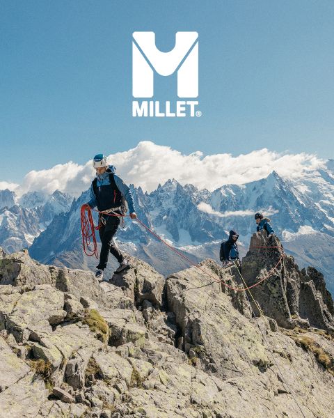 Drei Wanderer in voller Ausrüstung wandern durch eine Berglandschaft mit schneebedeckten Gipfeln. Unten zu sehen ist eine Frau in einer Jacke, die ihren Kragen zurechtrückt. Im Hintergrund sind Berge zu sehen. Unten rechts ist das „Millet“-Logo zu sehen.