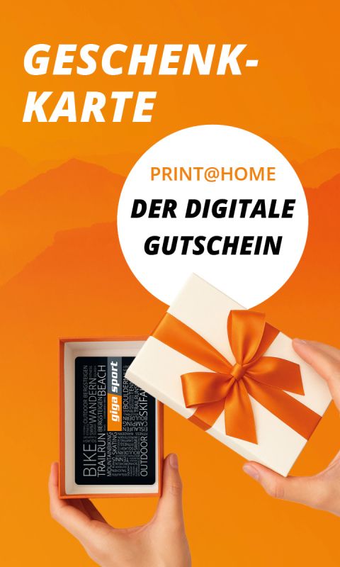 Eine Hand öffnet eine Geschenkschachtel mit einem orangefarbenen Band und enthüllt eine Geschenkkarte. Der Text lautet: "GESCHENKKARTE PRINT@HOME DER DIGITALE GUTSCHEIN.