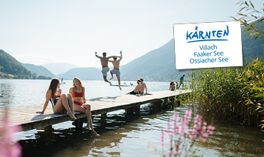 Vier Radfahrer fahren einen kurvenreichen Waldweg hinunter, im Hintergrund ein Schild mit der Aufschrift "Kärnten Villach Faaker See Ossiacher See".
