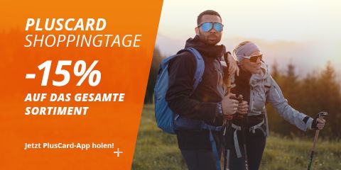 Zwei Wanderer mit Trekkingstöcken stehen bei Sonnenuntergang im Freien. Text wirbt "Pluscard Shoppingtage" mit 15% Rabatt auf das gesamte Sortiment.
