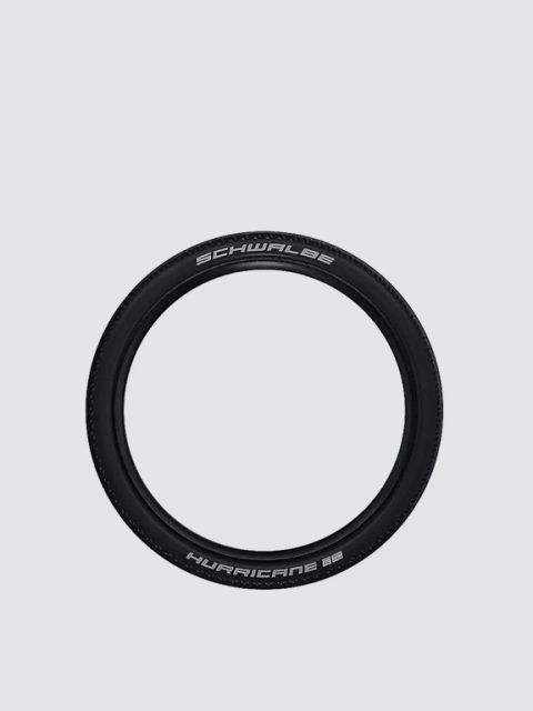 Ein schwarzer Schwalbe Hurricane Fahrradreifen mit weißem Schriftzug vor einem schlichten hellgrauen Hintergrund.