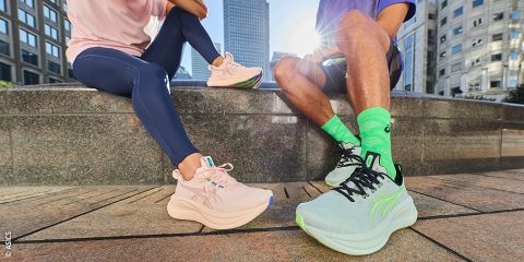 Vier Personen joggen auf einem gepflasterten Weg im Grünen. Sie tragen verschiedenfarbige Sportkleidung. Am Himmel ist der Text „LAUFSCHUH GUIDE“ zu sehen.