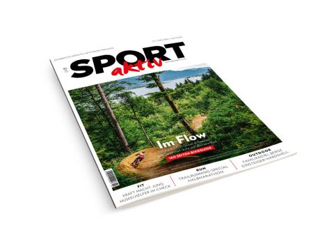 Titelbild der Zeitschrift "Sport aktiv" mit einem Mountainbiker, der auf einem Waldweg inmitten grüner Bäume fährt, mit Textüberschriften in deutscher Sprache.