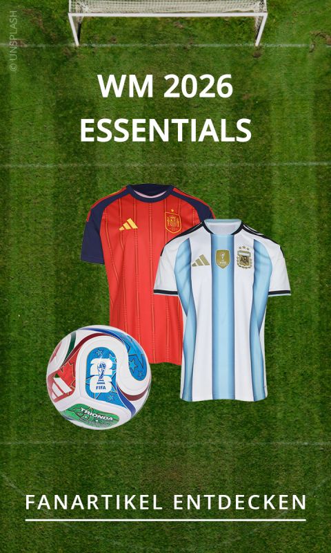 Zwei Fußballtrikots, ein WM-Ball und ein Fußballtor auf Rasen, mit den Texten: „WM 2026 Essentials“ und „Fanartikel entdecken“.