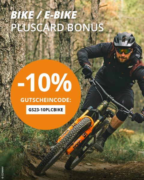 Ein Mann fährt mit einem Mountainbike auf einem unbefestigten Weg; ein orangefarbener Kreis wirbt für "-10% Gutschein code: GS23-10PLCBIKE" für einen Fahrrad/E-Bike Pluscard Bonus.