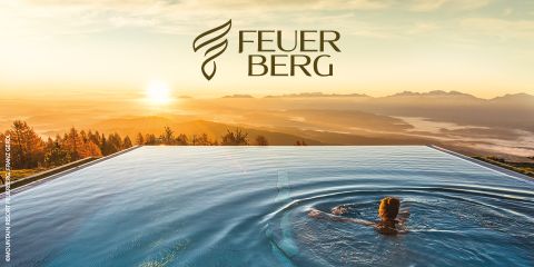 Eine Person schwimmt in einem Infinity-Pool mit Blick auf eine malerische Berglandschaft bei Sonnenuntergang. Der Himmel ist in warmen Farben gehalten, und darüber steht das Wort „Feverberg“ in Form eines Flammenmusters.
