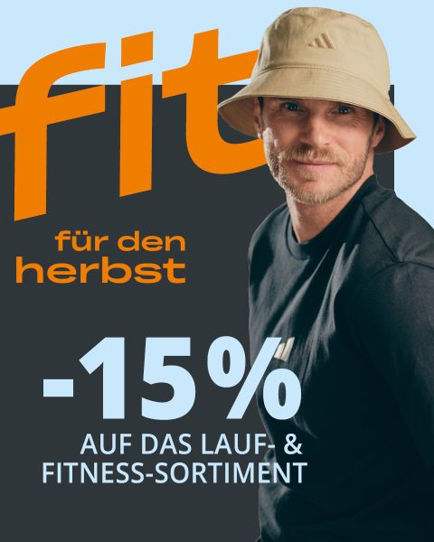Ein Mann mit einem beigen Bucket-Hat und einem schwarzen T-Shirt mit der Aufschrift: „Fit für den Herbst – 15 % auf das Lauf- und Fitness-Sortiment“ auf grauem Hintergrund.