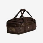 Eine braune North Face-Reisetasche mit schwarzen Trägern und Reißverschlüssen, auf deren Seite das Markenlogo zu sehen ist, vor einem weißen Hintergrund.