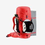Roter Wanderrucksack, an dem ein Helm, Trekkingstöcke und eine aufgerollte Schaumstoff-Isomatte befestigt sind, abgebildet vor einem schlichten weißen Hintergrund.