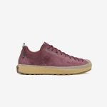 Ein burgunderroter Sneaker aus Wildleder mit hellbrauner Gummisohle, Seitenansicht, vor weißem Hintergrund. Der Schuh hat schwarze Schnürsenkel und ein Low-Top-Design.