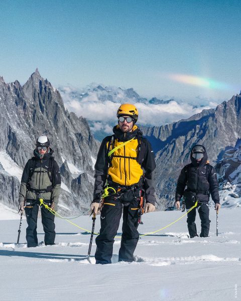 Zwei Bilder auf Felshintergrund. Links: Frau in lila Wanderkleidung mit Helm. Rechts: Person in grün-blauer Kleidung mit gelbem Rucksack, Kletterausrüstung und aufgerolltem Seil. Text: „OUTDOOR-TYP ALPINIST“.