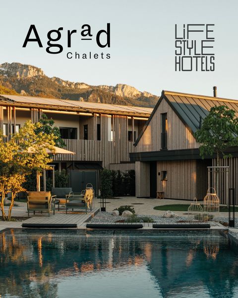 Moderne Holzchalets am Pool mit Blick auf die Berge, Sitzgelegenheiten im Freien und die Logos „Agrad Chalets“ und „LIFE STYLE HOTELS“ am Himmel.