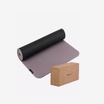 Auf einem weißen Hintergrund liegt eine aufgerollte Yogamatte in Schwarz und Grau neben einem rechteckigen Yogablock aus Kork.